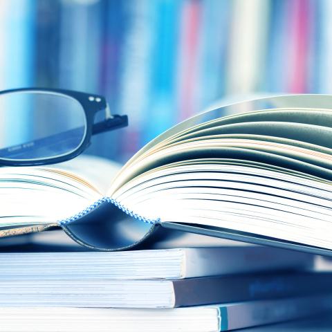 Aufgeschlagenes Buch mit Brille